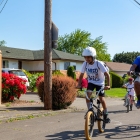 father and two sons riding bikes in street