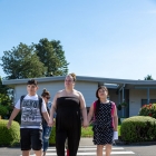 three individuals walking in crosswalk